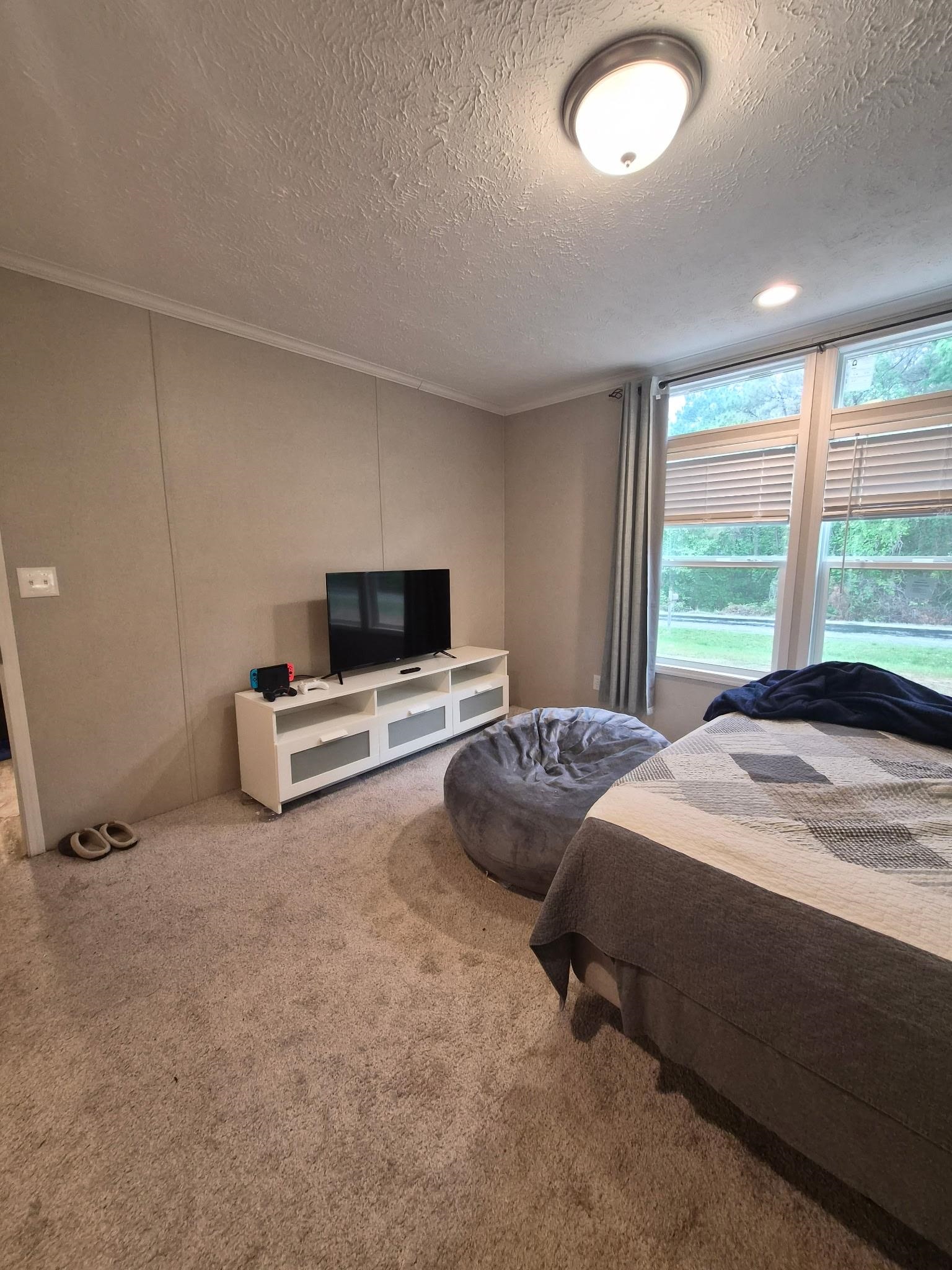 510 Potts Chapel Road Jackson, TN 38305 - Photo 15 of 30 Carpeted bedroom featuring a decorative wall, a textured ceiling, and ornamental molding