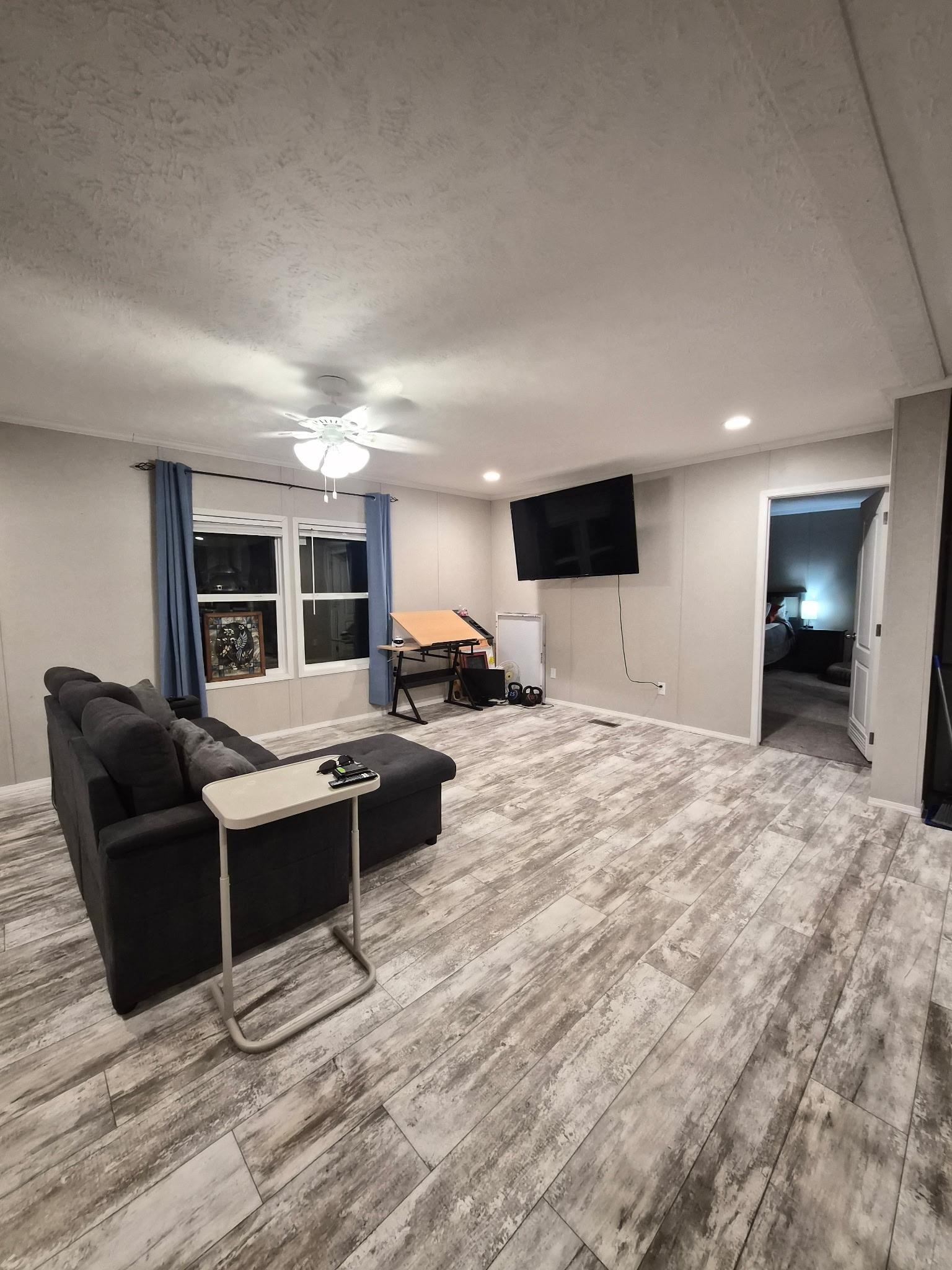 510 Potts Chapel Road Jackson, TN 38305 - Photo 7 of 30 Living room with light wood finished floors, a ceiling fan, recessed lighting, and a textured ceiling