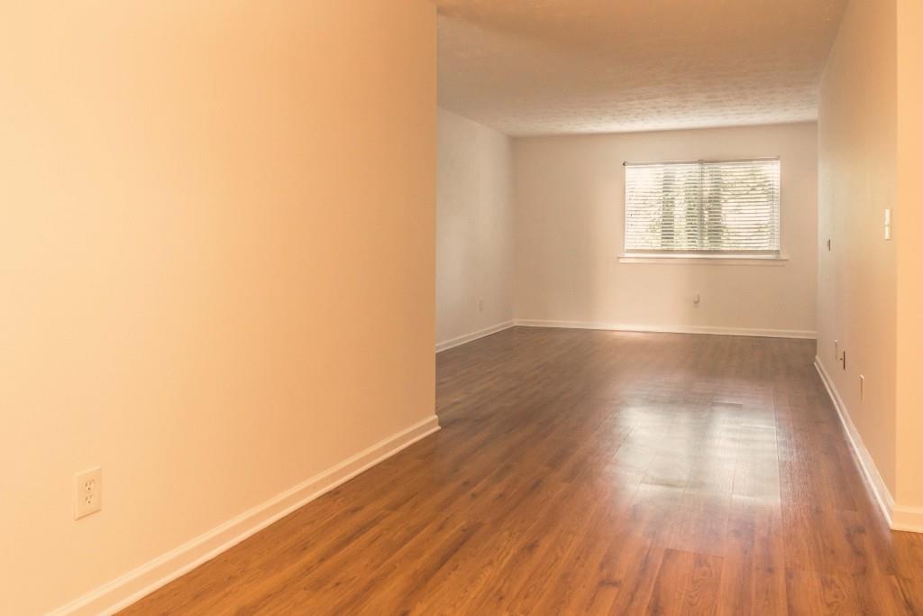 3796 Kensingwood Trace, Unit 3796 Decatur, GA 30032 - Photo 1 of 1 an empty room with wooden floor and windows
