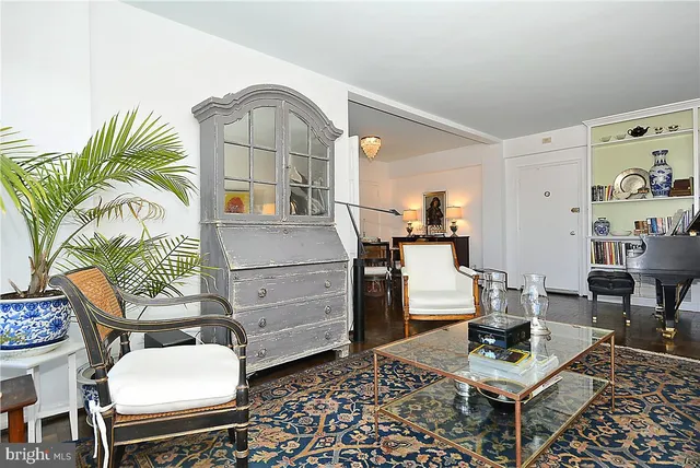 a living room with furniture and a painting on the wall