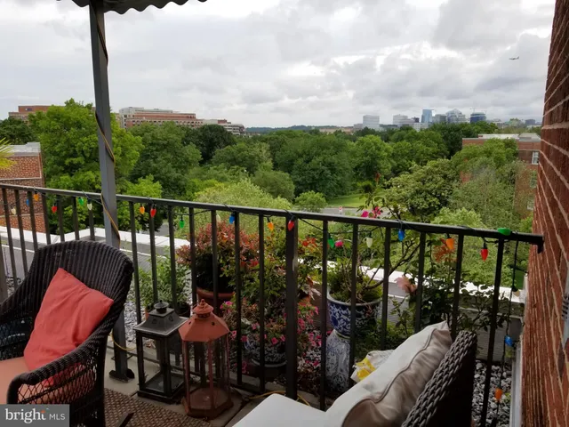 a balcony with wooden floor table and chairs