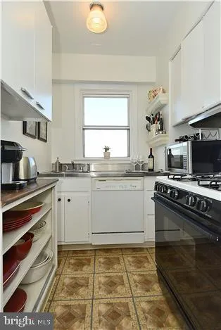 a kitchen with a stove a sink and a window