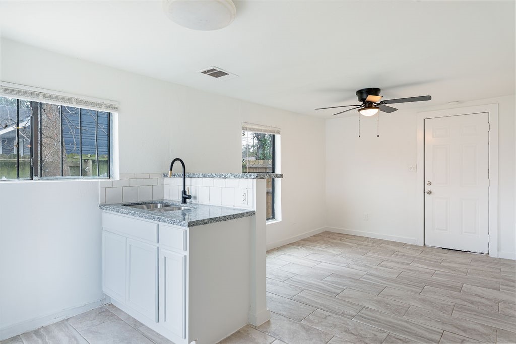 1307 Boulder Street Houston, TX 77012 - Photo 10 of 14 a view of a kitchen with a sink a ceiling fan and refrigerator in a room