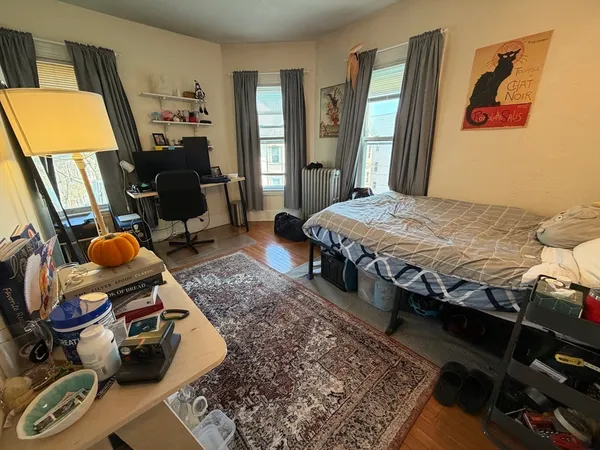 a bedroom with bed and wooden floor