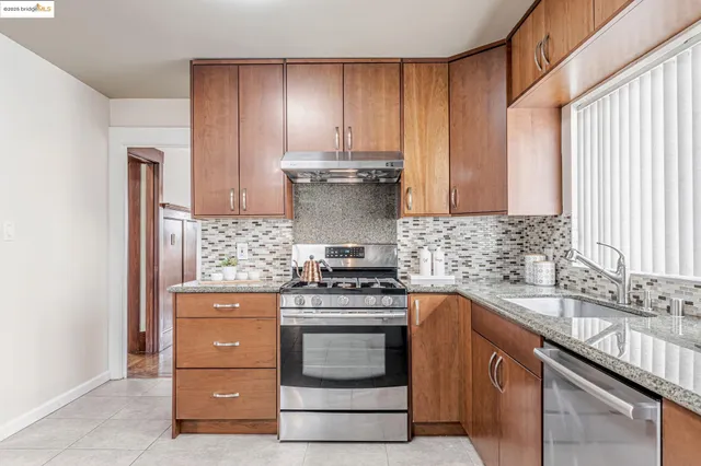 a kitchen with granite countertop a stove sink and cabinets