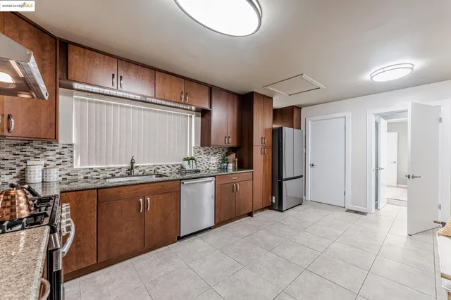 a kitchen with stainless steel appliances granite countertop a refrigerator and a stove top oven