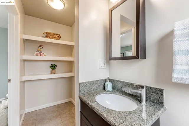 a bathroom with a granite countertop sink and a mirror