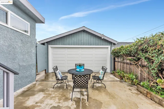a backyard of a house with table and chairs
