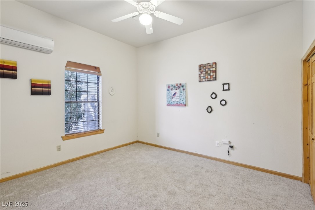 519 North Racetrack Road Henderson, NV 89015 - Photo 46 of 98 Empty room with an AC wall unit, carpet flooring, ceiling fan, and baseboards