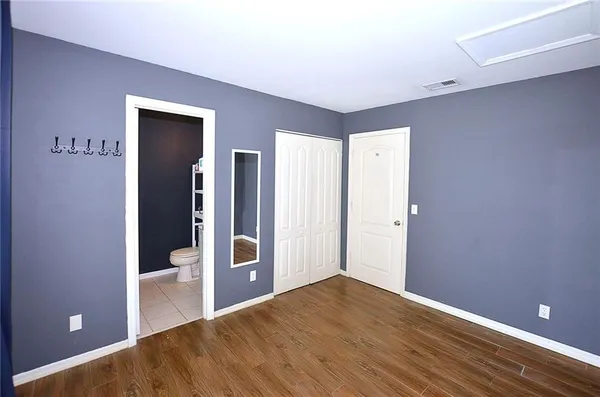 a view of a hallway with wooden floor and a living room