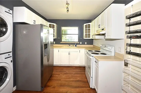a kitchen with a refrigerator sink stove and cabinets