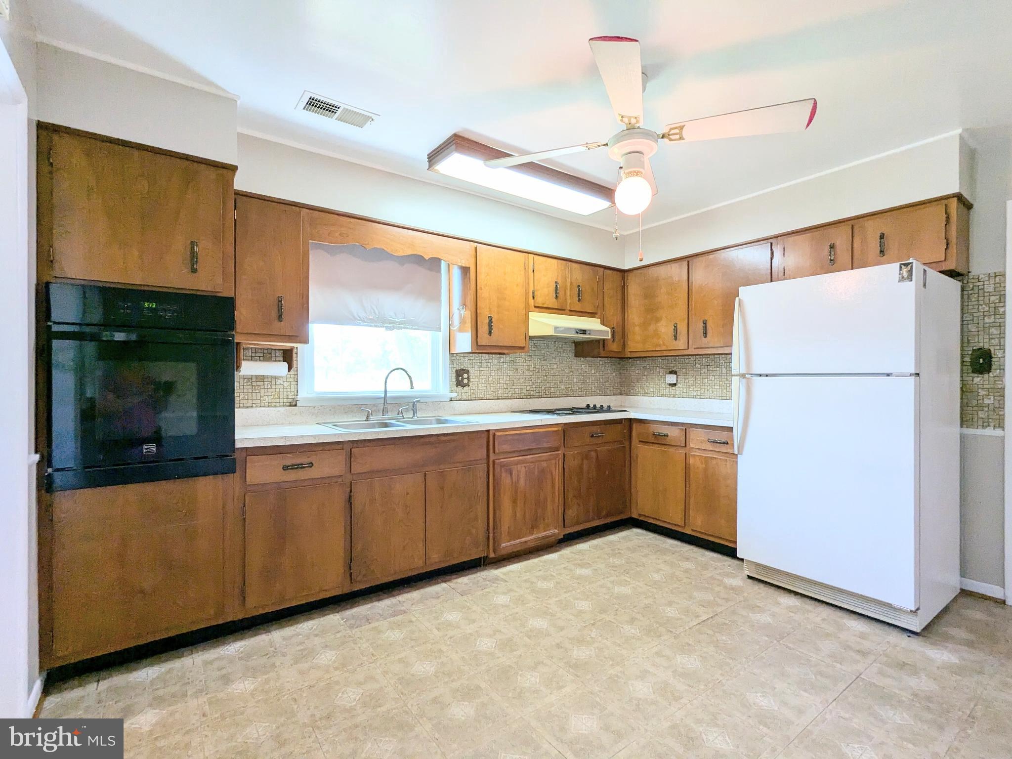 24675 Blackistone Road Hollywood, MD 20636 - Photo 13 of 27 a kitchen with a refrigerator a sink and cabinets