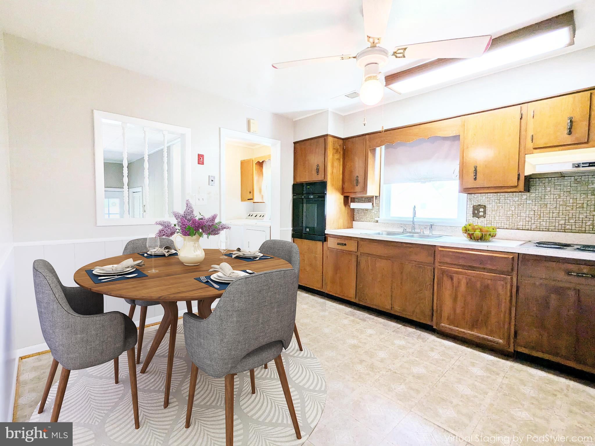 24675 Blackistone Road Hollywood, MD 20636 - Photo 3 of 27 a kitchen with a dining table chairs and white cabinets