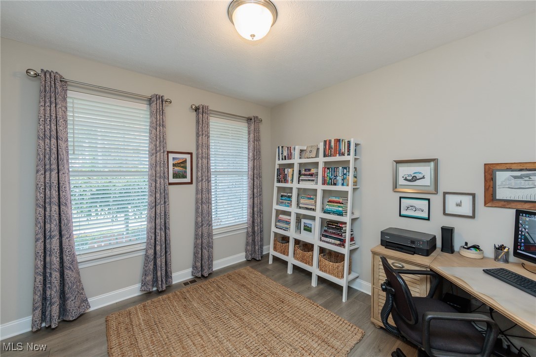 2041 Jaycox Road Avon, OH 44011 - Photo 6 of 50 Home office featuring dark wood-style flooring and a textured ceiling