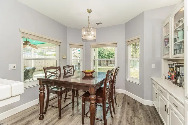 a large white kitchen with a large island stainless steel appliances a sink and a large window