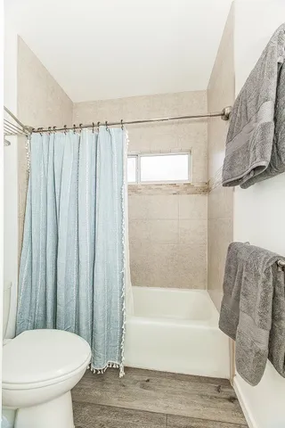 a bathroom with a granite countertop sink a toilet and a mirror