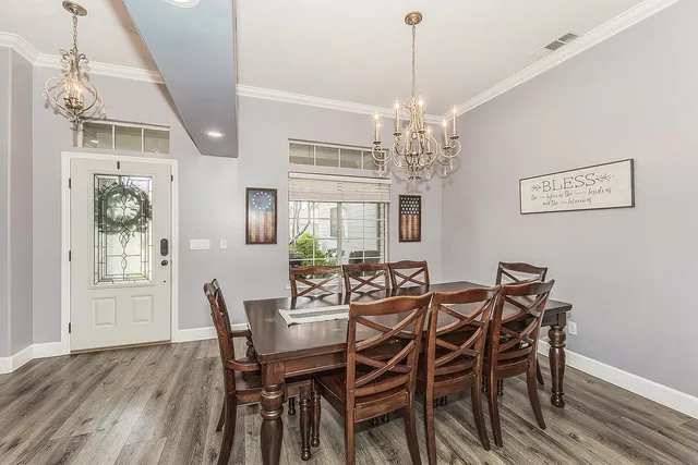 a view of a dining room with furniture a chandelier and wooden floor