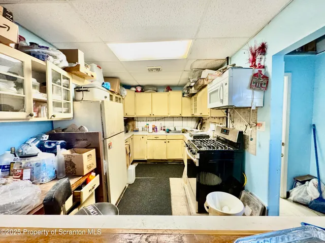 a view of a white house with a big yard and large trees