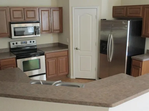 a kitchen with stainless steel appliances granite countertop a refrigerator stove and microwave