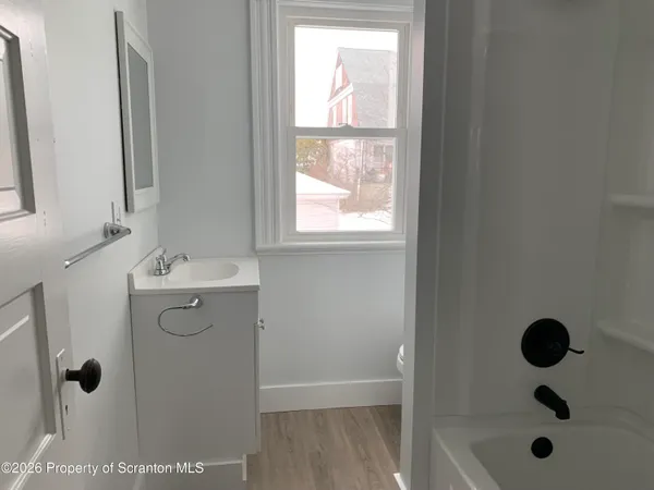 a bathroom with a shower sink and mirror