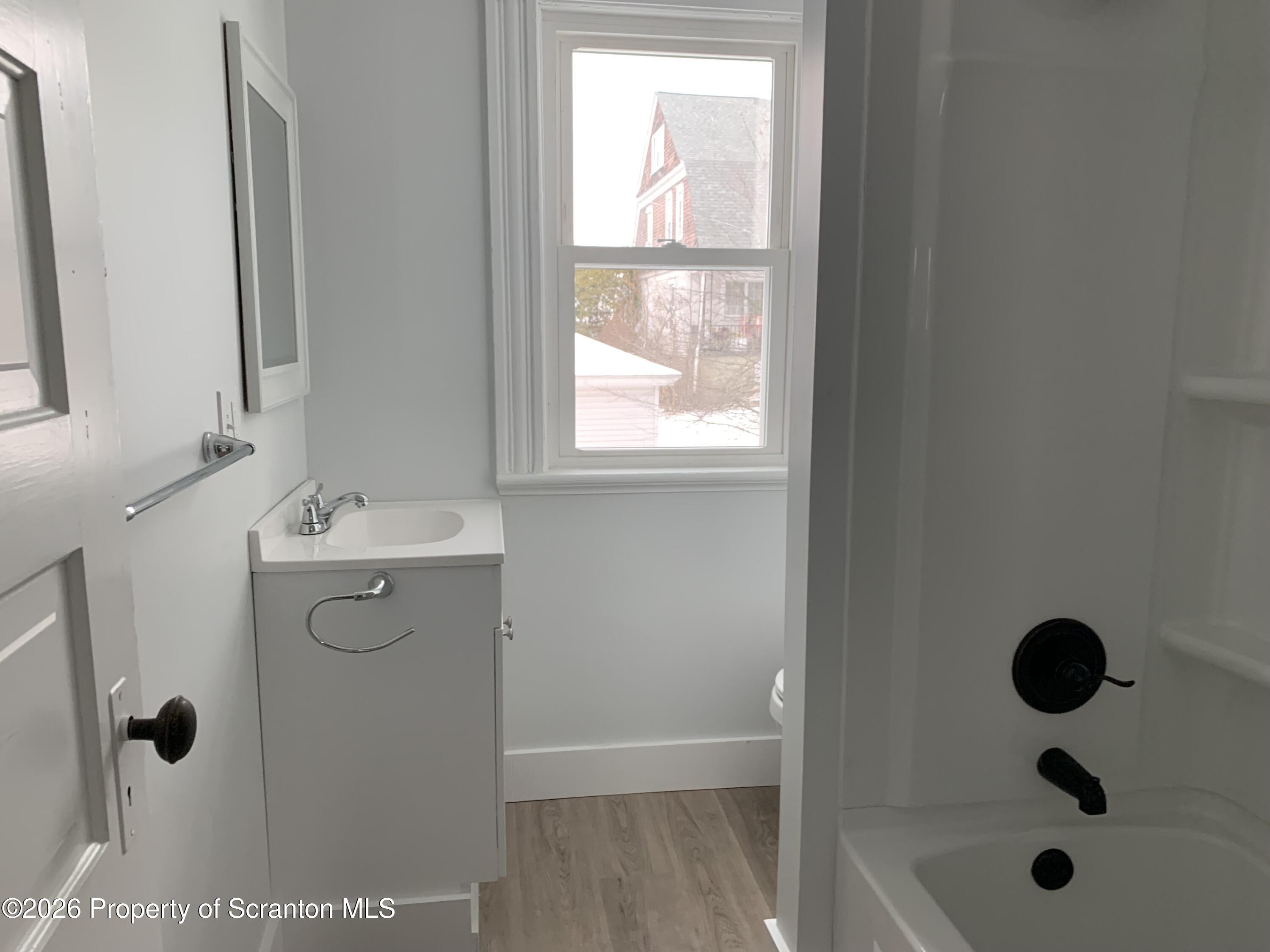 709 Meade Street Dunmore, PA 18512 - Photo 12 of 38 a bathroom with a shower sink and mirror