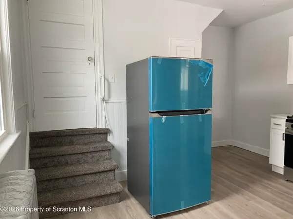 a walk in closet with wooden floor