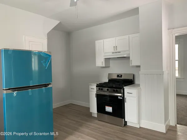 a kitchen with a refrigerator and a stove top oven