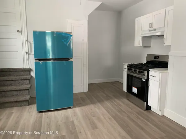 a kitchen with a refrigerator and a stove top oven