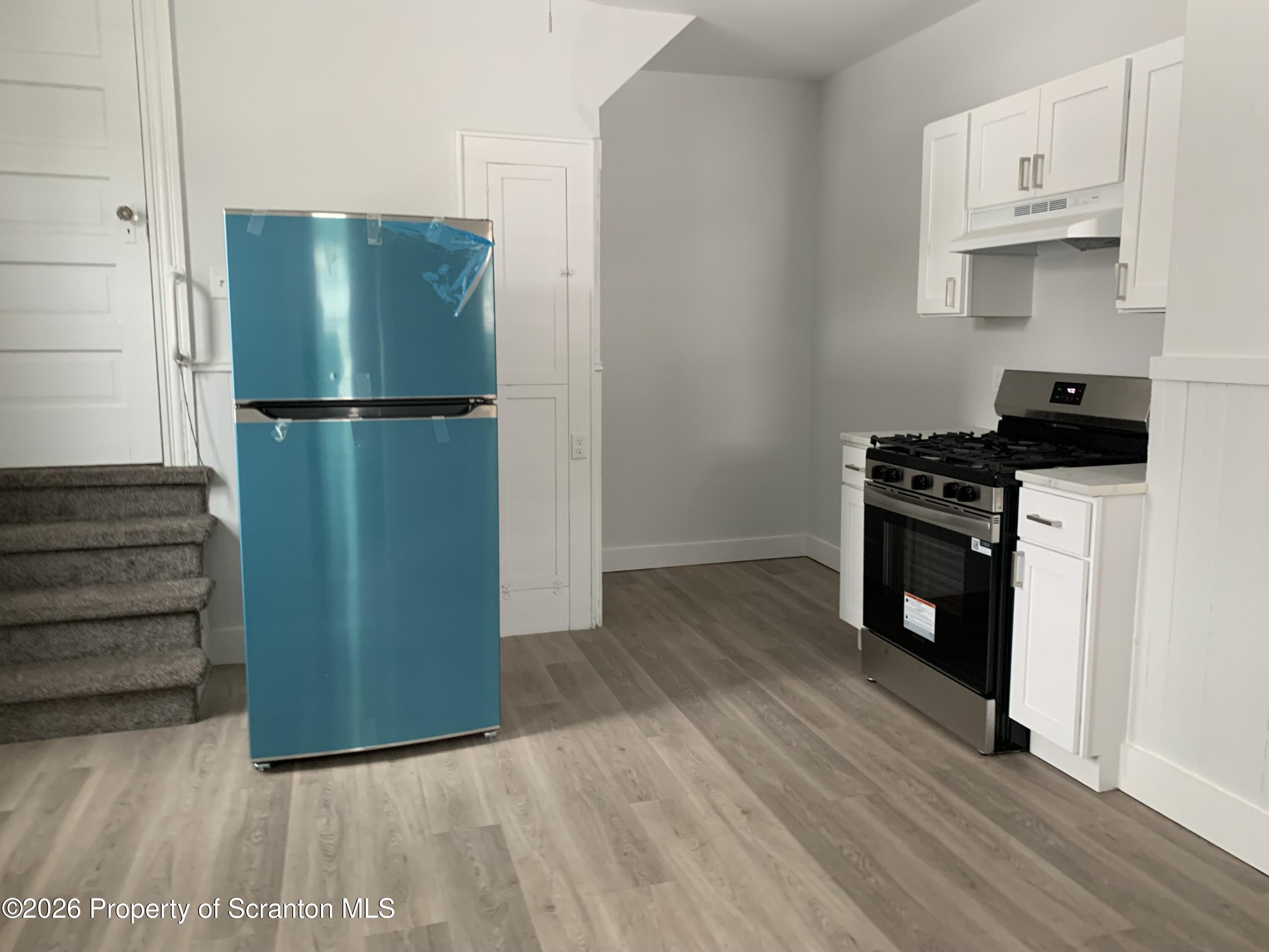 709 Meade Street Dunmore, PA 18512 - Photo 7 of 38 a kitchen with a refrigerator and a stove top oven