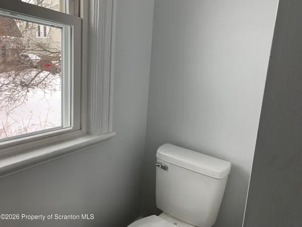 a white toilet sitting next to a window