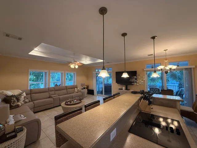 a living room with furniture a flat screen tv and kitchen view