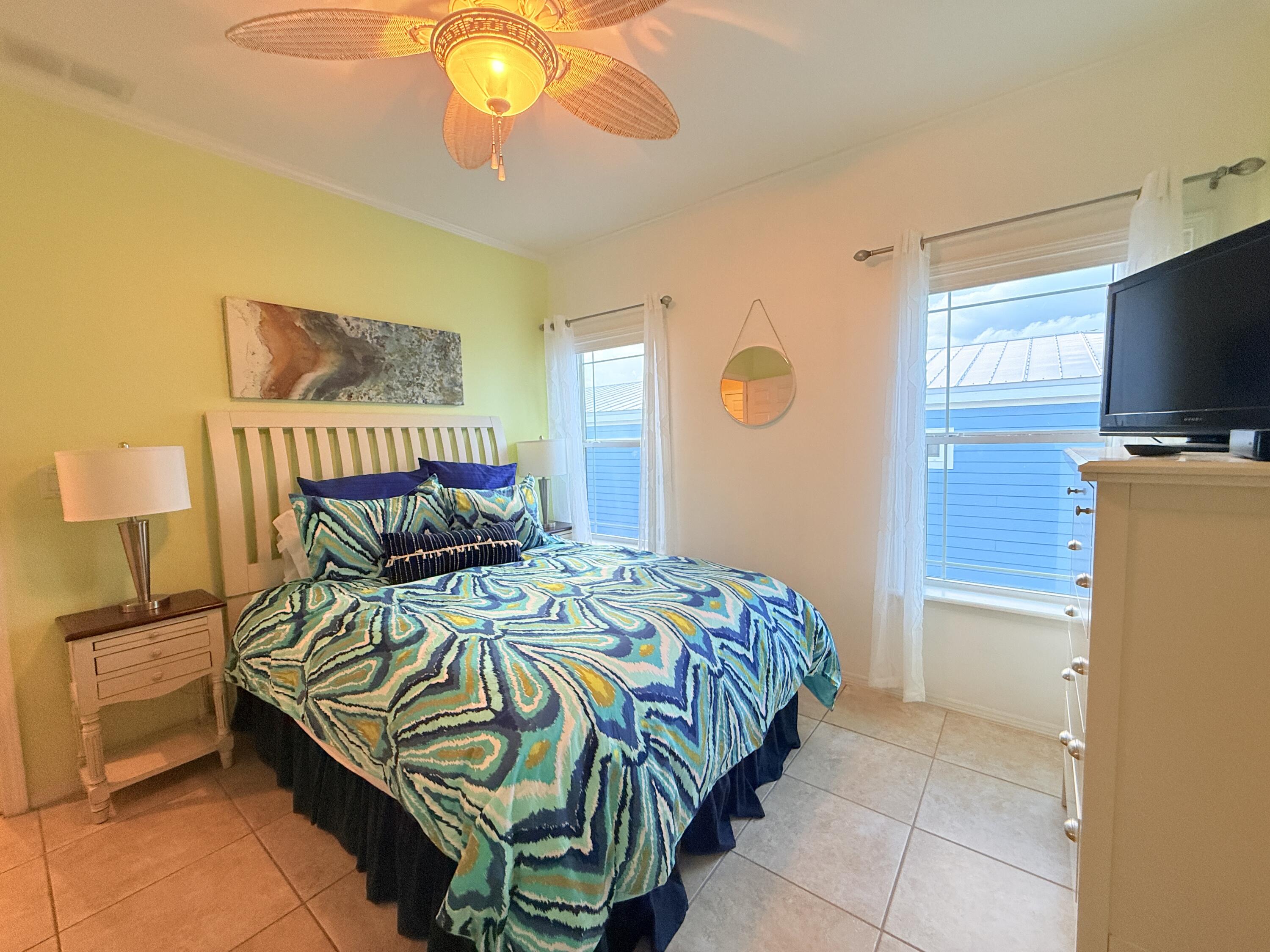 903 Tropical Lane Key Largo, FL 33037 - Photo 17 of 46 a bedroom with a bed and a flat tv screen on the dresser