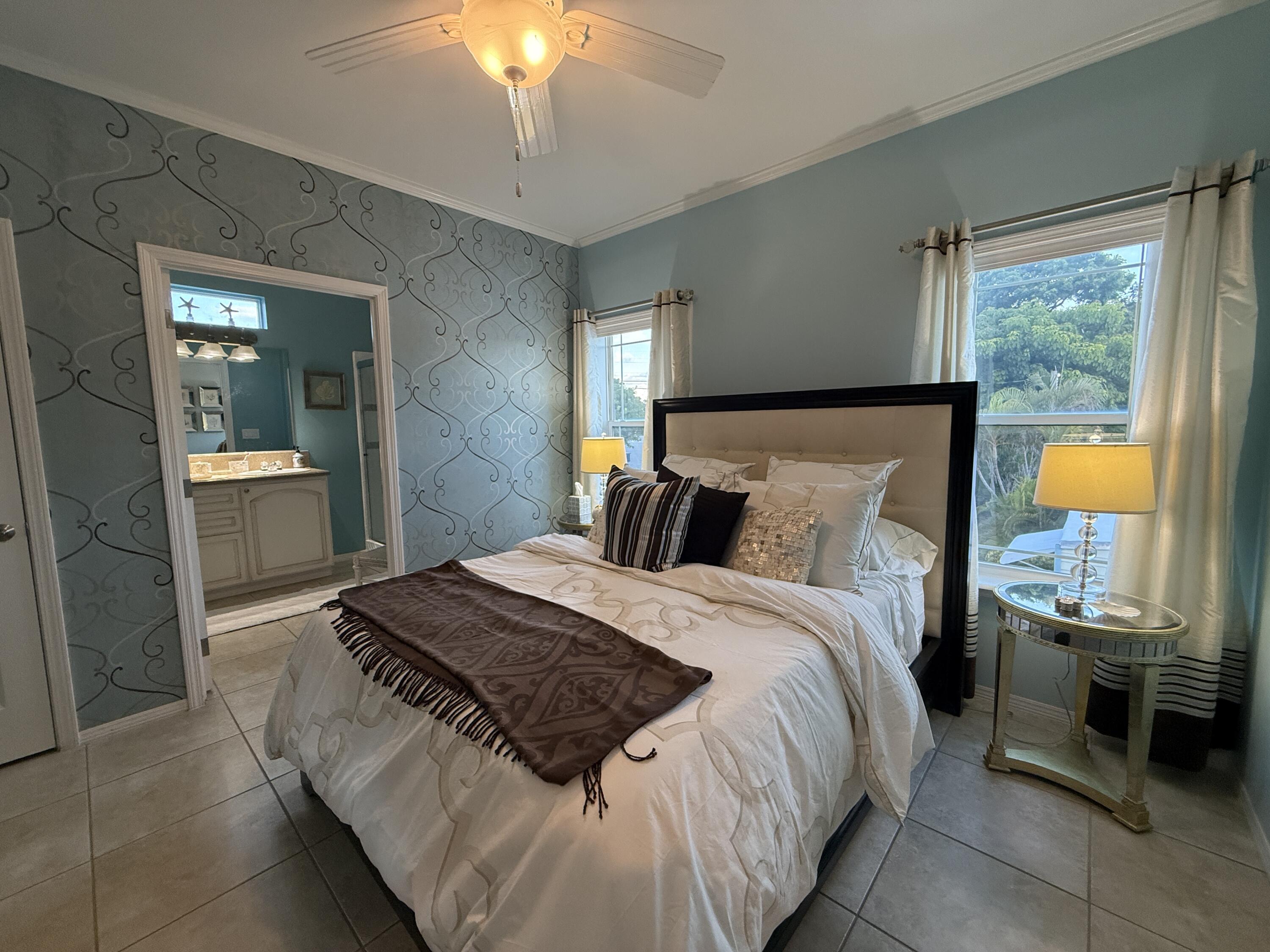 903 Tropical Lane Key Largo, FL 33037 - Photo 20 of 46 a bedroom with a bed and a chandelier