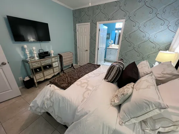 a bedroom with a bed and a flat screen tv