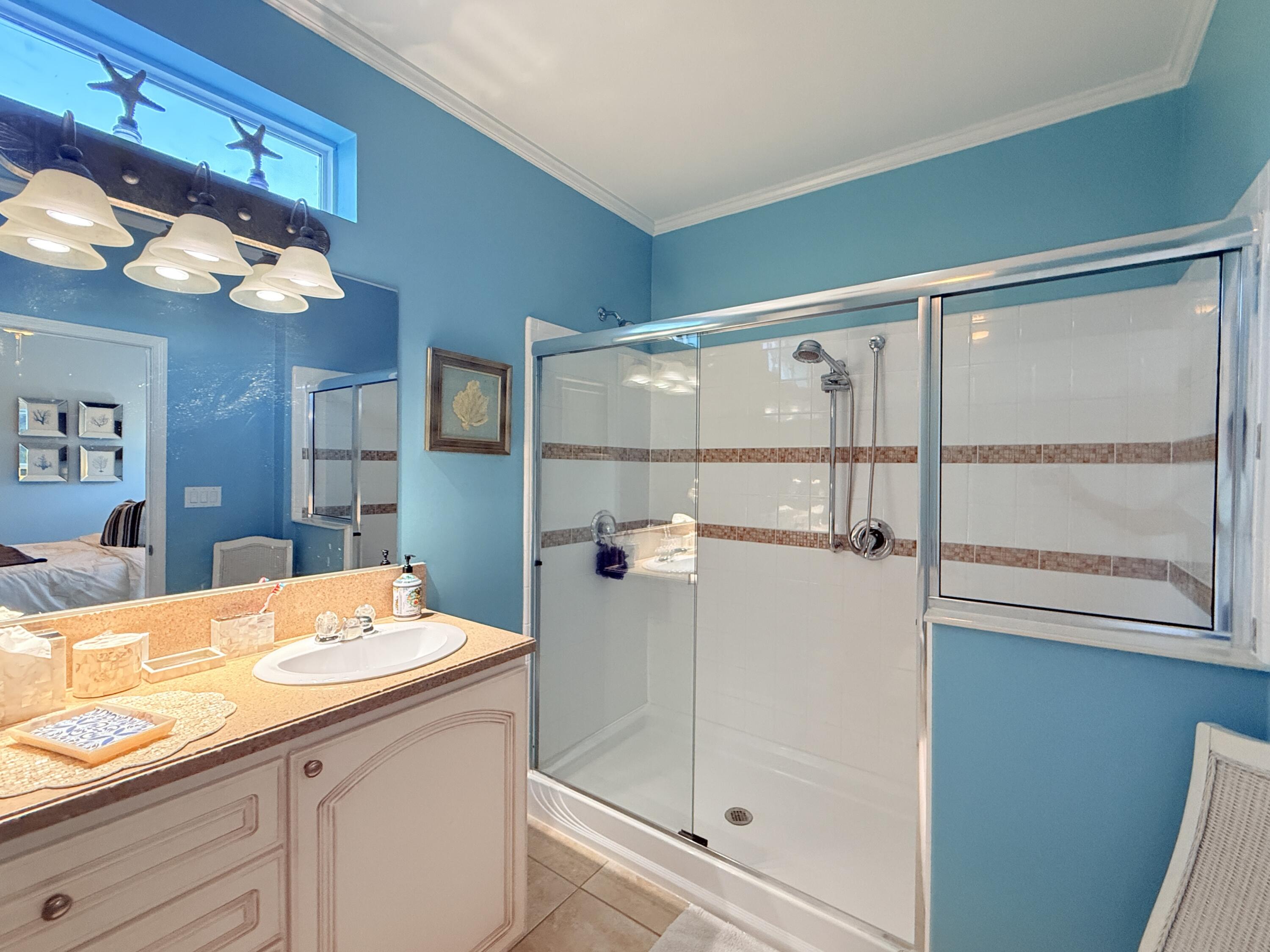 903 Tropical Lane Key Largo, FL 33037 - Photo 22 of 46 a bathroom with a sink a large mirror and shower
