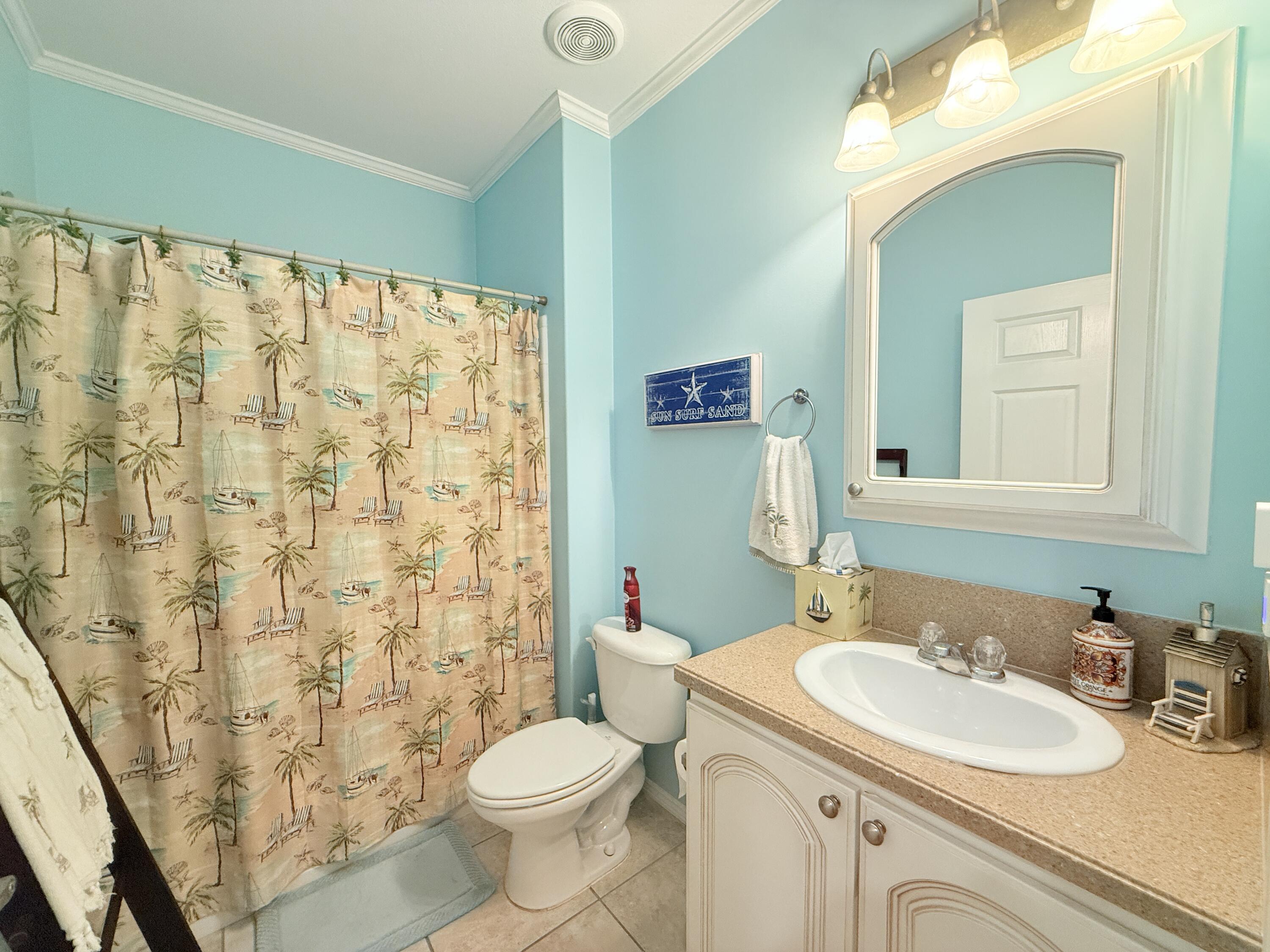 903 Tropical Lane Key Largo, FL 33037 - Photo 26 of 46 a bathroom with a sink a toilet and shower curtain
