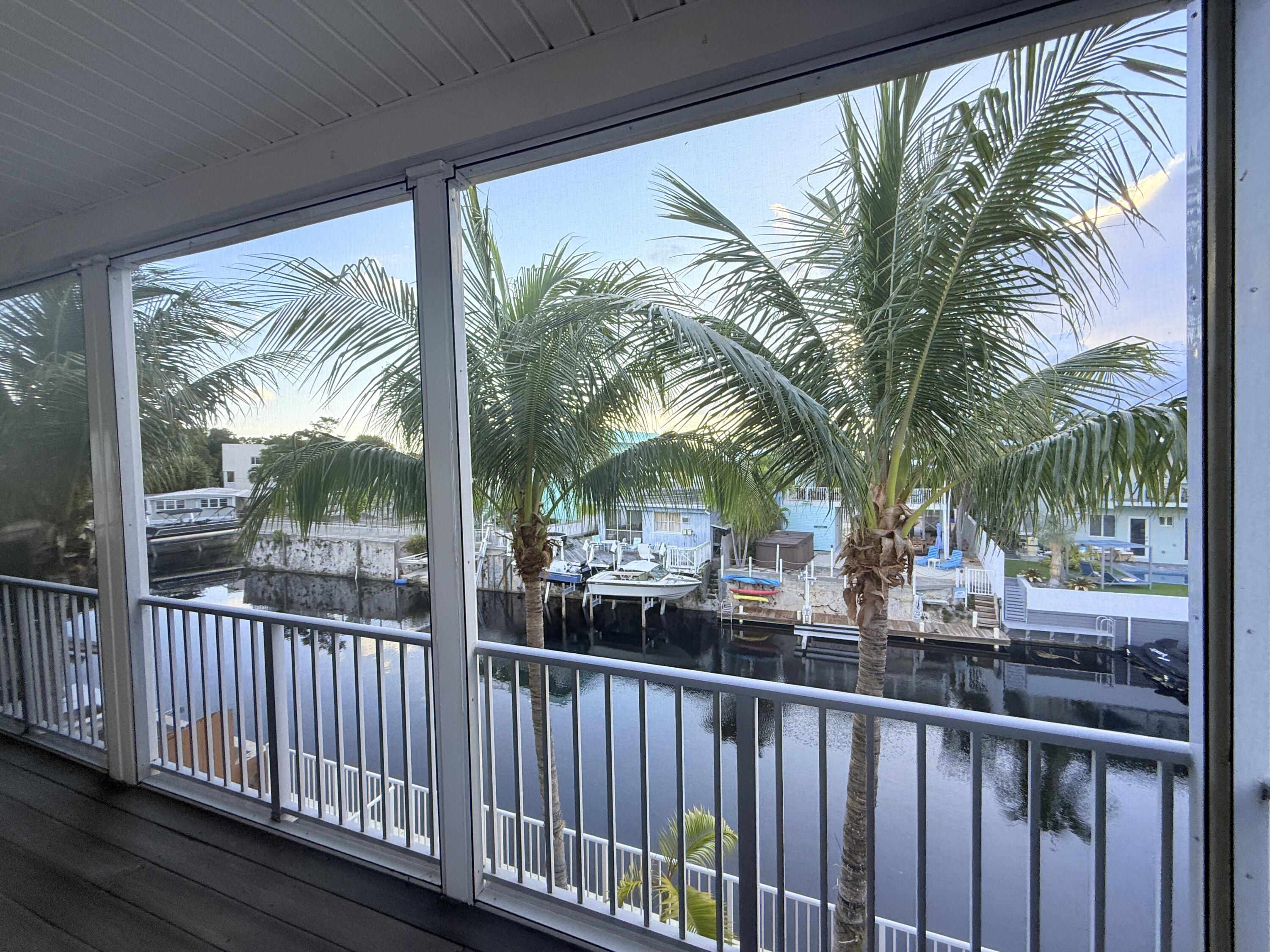 903 Tropical Lane Key Largo, FL 33037 - Photo 32 of 46 a view of a house with large windows and wooden fence