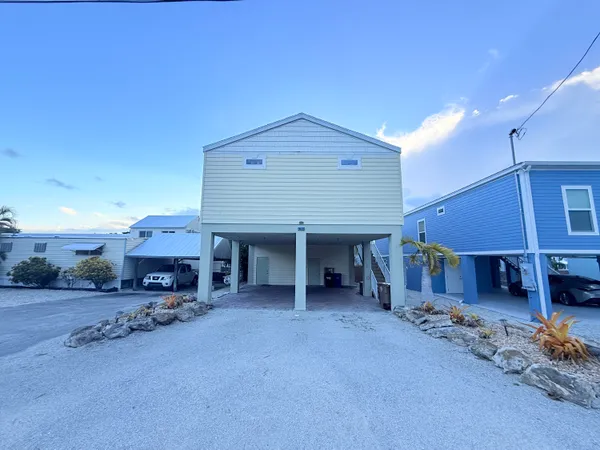 a view of a house with a patio and a yard