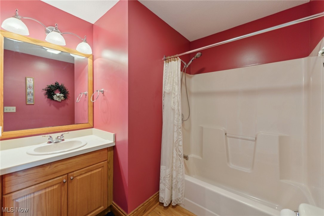 45230 Cemetery Road Wellington, OH 44090 - Photo 23 of 50 Bathroom featuring vanity, shower / tub combo, wood finished floors, and baseboards