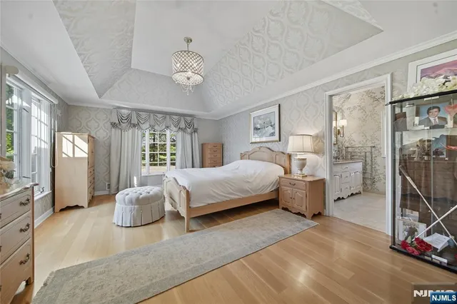 a spacious bedroom with a large bed and a chandelier