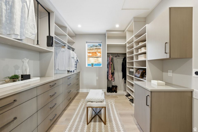 2002 East Outlaw Road Kamas, UT 84036 - Photo 41 of 65 Expansive custom closet featuring extensive built-in cabinetry and shelving, a window providing natural light, recessed lighting, and light wood-finish flooring