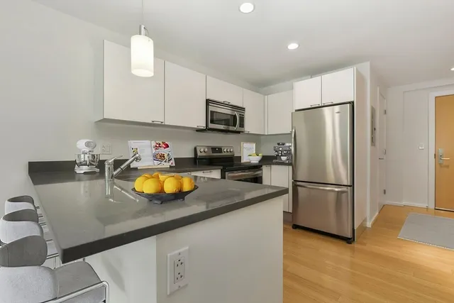 a kitchen with stainless steel appliances granite countertop a refrigerator a stove a sink a microwave and a refrigerator