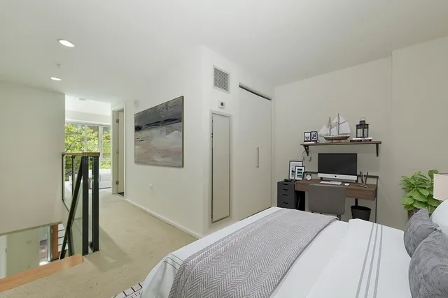 a bedroom with a bed and a flat tv screen on the dresser