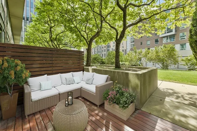 a view of a patio with couches table and chairs and potted plants