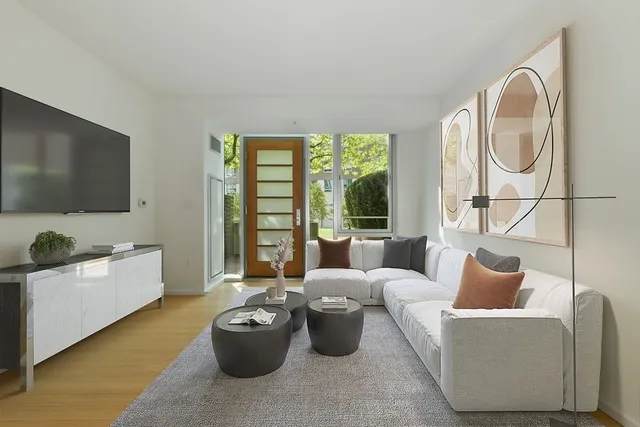 a living room with furniture a flat screen tv and floor to ceiling window