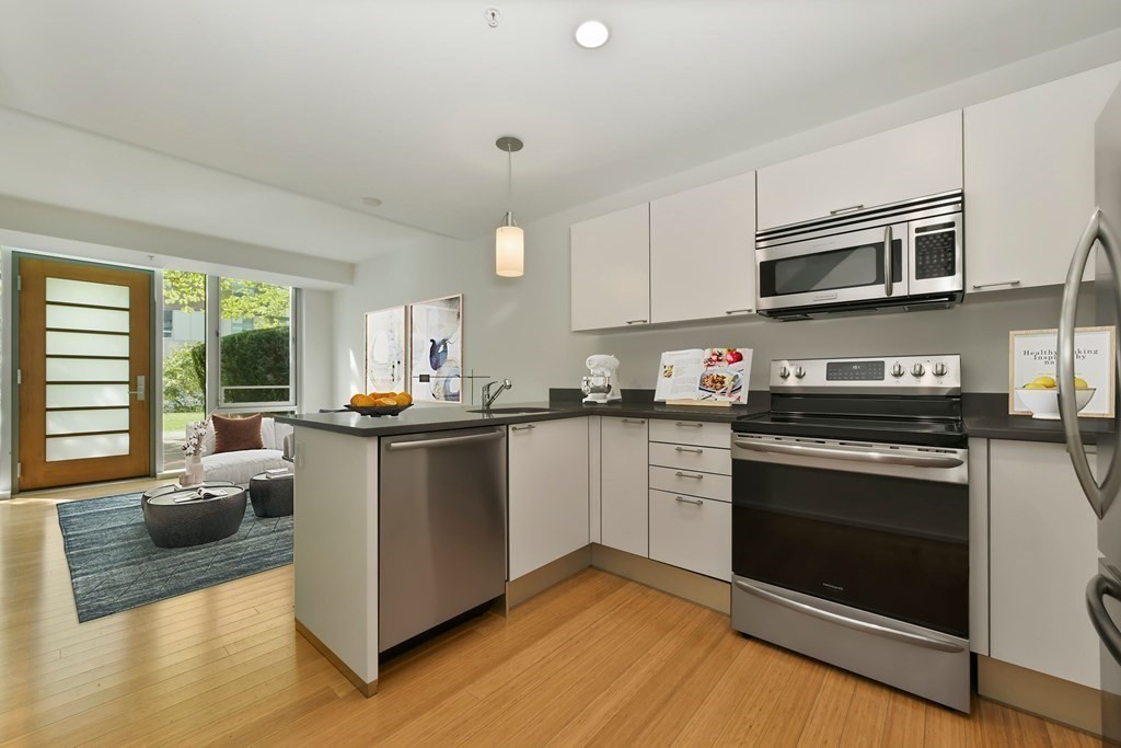 2 Earhart Street, Unit 120 Cambridge, MA 02141 - Photo 7 of 42 a kitchen with stainless steel appliances granite countertop a stove a sink and a microwave