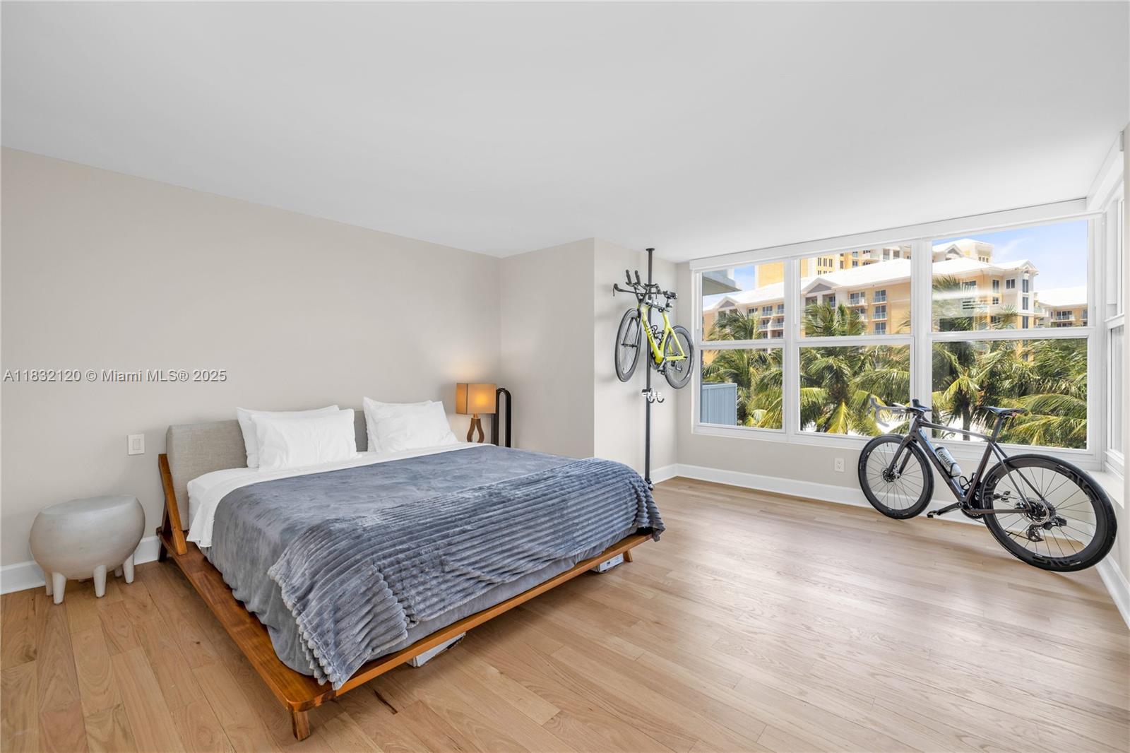 615 Ocean Drive, Unit 6A Key Biscayne, FL 33149 - Photo 14 of 40 a bedroom with a bed and a table next to a large window