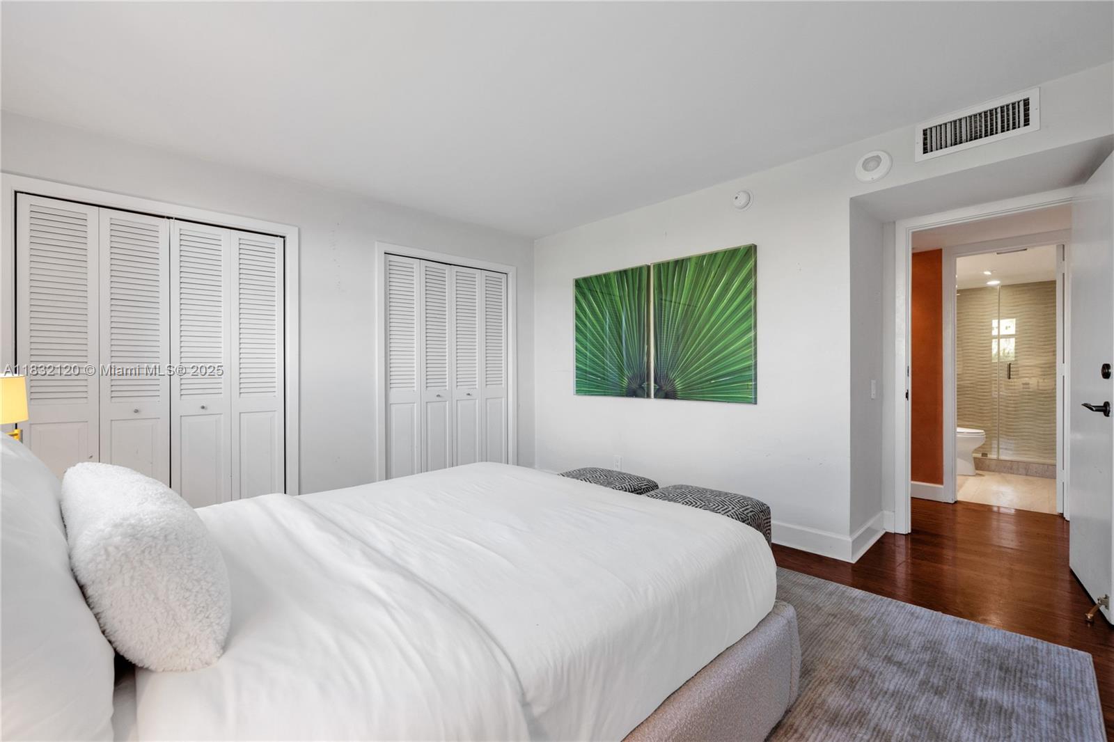 615 Ocean Drive, Unit 6A Key Biscayne, FL 33149 - Photo 20 of 40 a bedroom with a large bed and a wooden floor