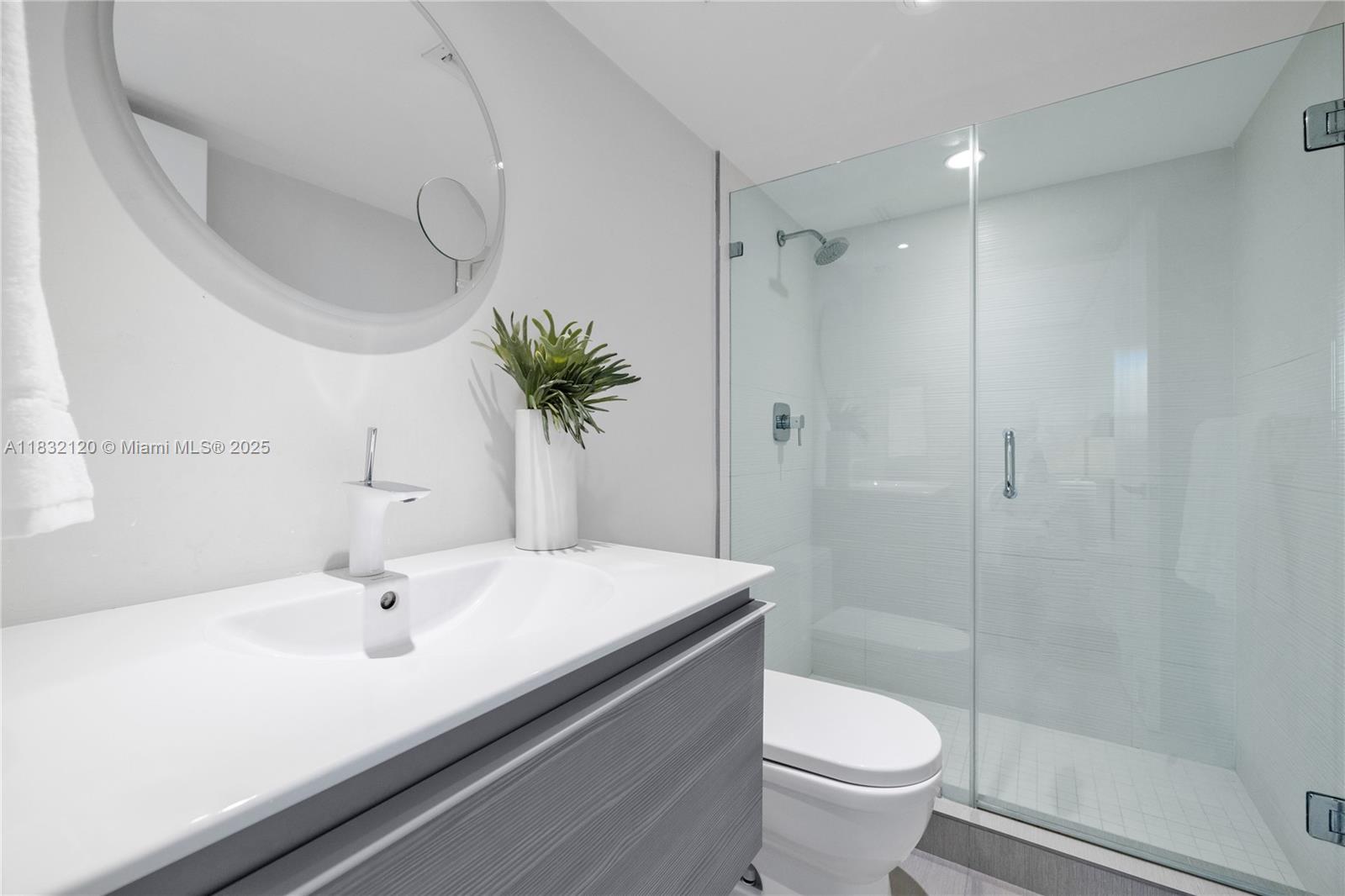 615 Ocean Drive, Unit 6A Key Biscayne, FL 33149 - Photo 22 of 40 a bathroom with a sink a toilet and a mirror