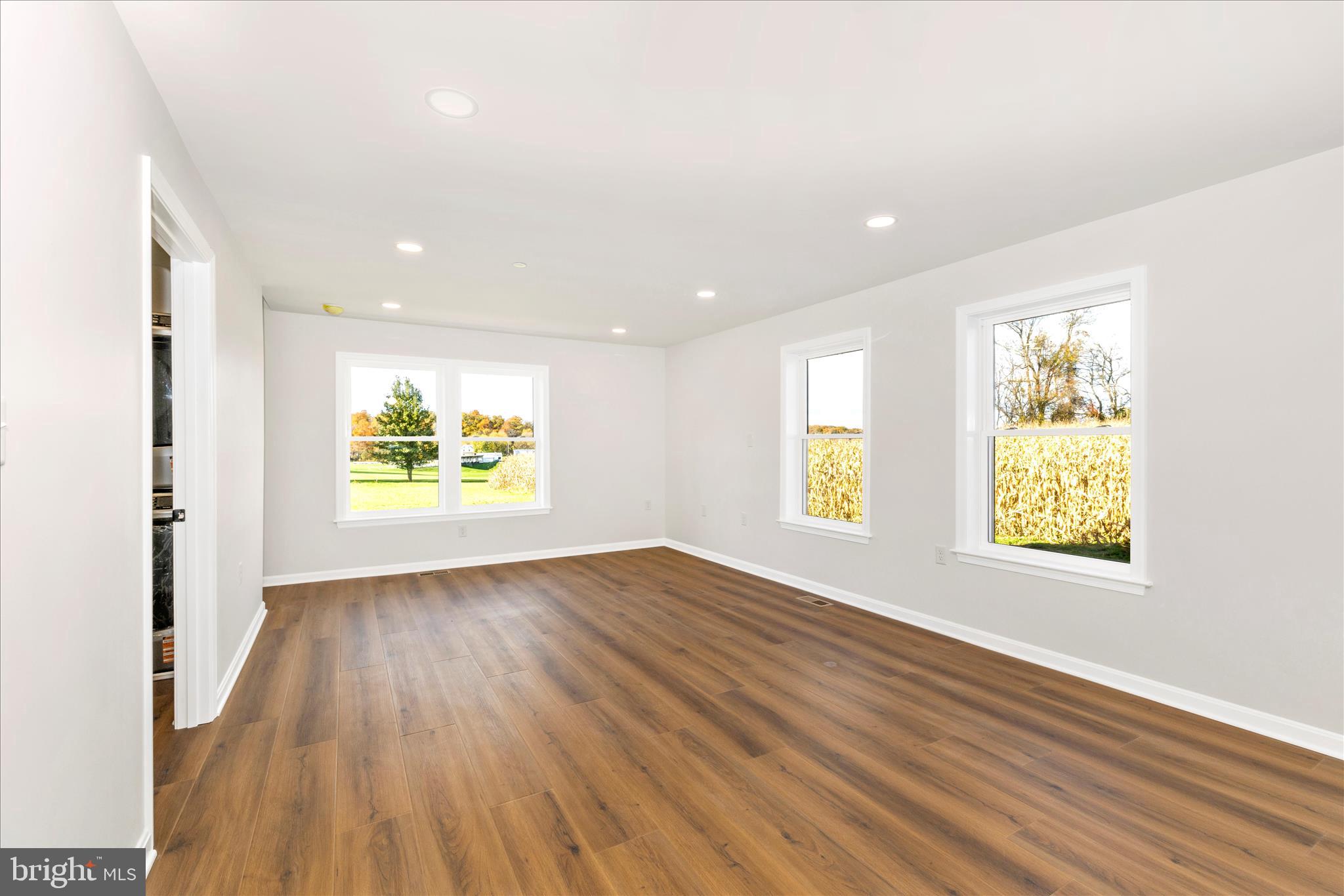 10910 Liberty Road Frederick, MD 21701 - Photo 14 of 51 an empty room with windows and wooden floor
